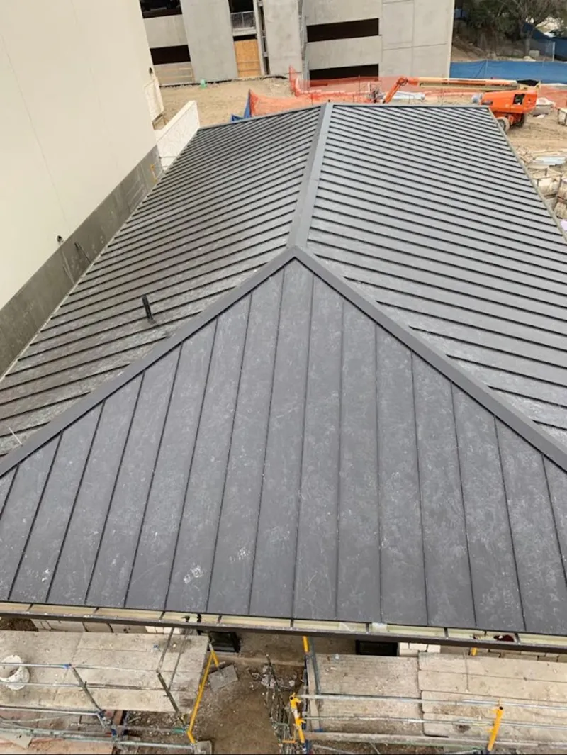 Commercial metal roof construction with crane equipment in Loudon